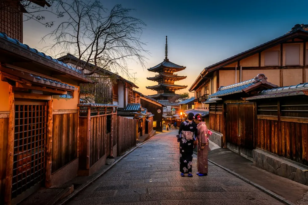 Traditional Kyoto street leading toward a pagoda at dusk